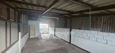 Spacious industrial-style storage unit with concrete floors and metal roofing, ideal for versatile use.