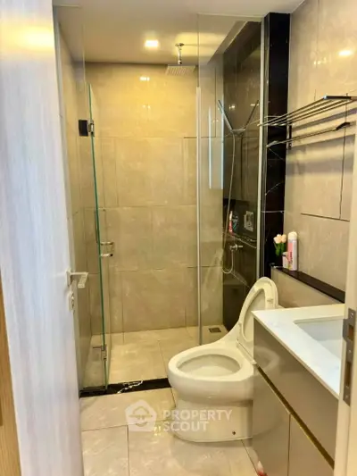 Modern bathroom with glass shower and sleek fixtures in a contemporary apartment.