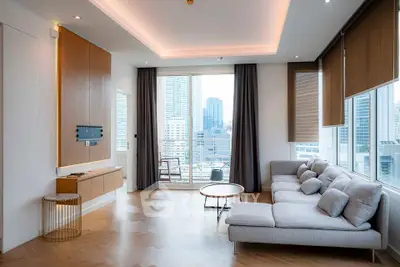 Modern living room with city view, featuring stylish furniture and large windows for natural light.