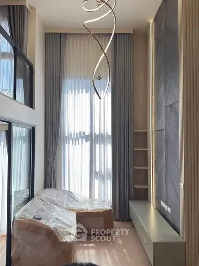 Modern living room with high ceiling and elegant lighting fixture