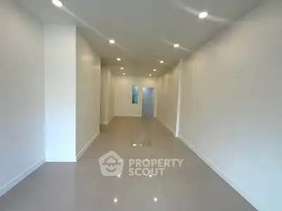 Spacious modern living room with glossy tiled floors and recessed lighting.