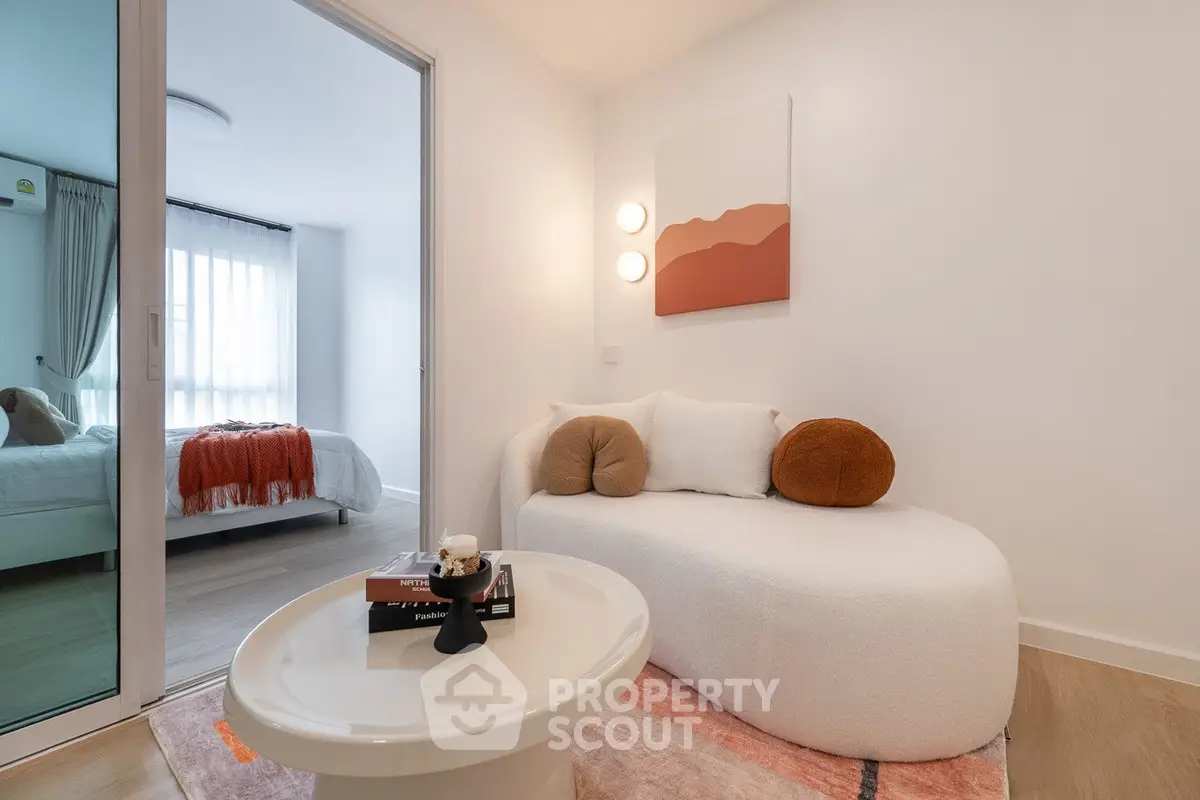 Modern cozy living room with stylish decor and view into a chic bedroom