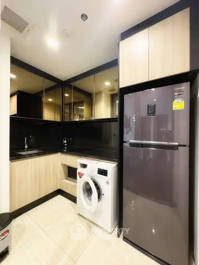 Modern kitchen with sleek appliances and stylish cabinetry in a compact layout.