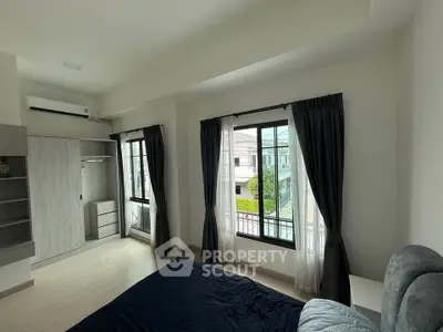 Bright bedroom with large windows and modern furnishings in a stylish home.