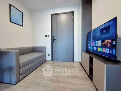 Modern living room with sleek sofa and flat-screen TV, perfect for cozy relaxation.