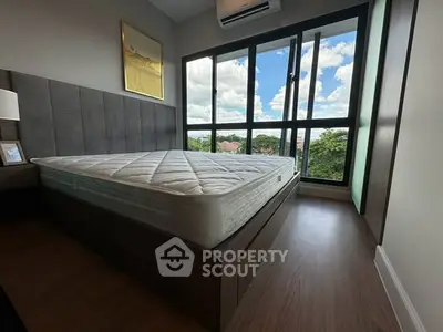 Modern bedroom with large windows offering a scenic view, featuring a comfortable bed and stylish decor.
