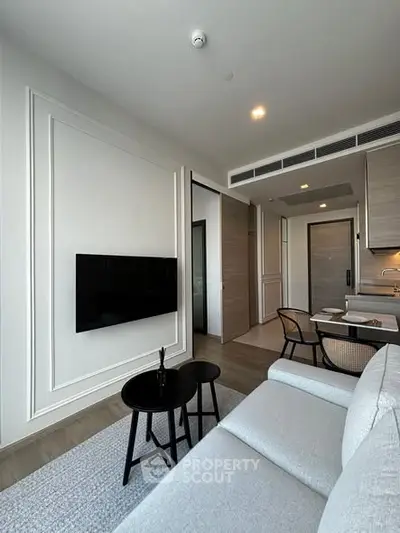 Modern living room with sleek design, featuring a wall-mounted TV, cozy sofa, and stylish dining area.