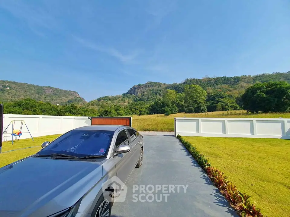 Scenic driveway with mountain view and landscaped garden