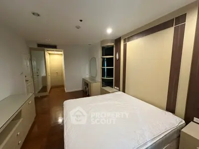 Spacious bedroom with elegant built-in storage and hardwood flooring