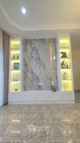 Luxurious living room with elegant marble feature wall and built-in illuminated shelves.