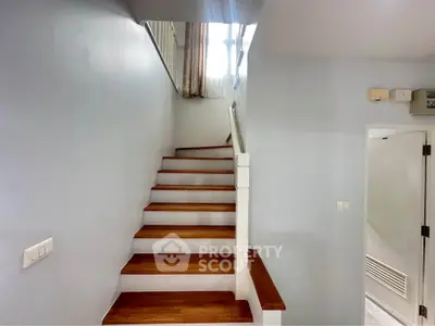 Elegant staircase with wooden steps and white railing in modern home interior