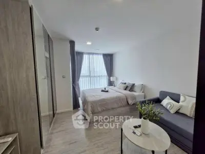 Modern bedroom with cozy decor and natural light in a stylish apartment.