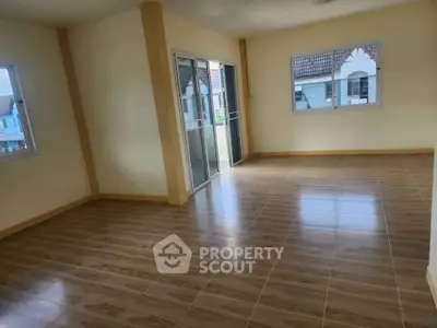 Spacious empty room with large windows and tiled flooring, ideal for customization.