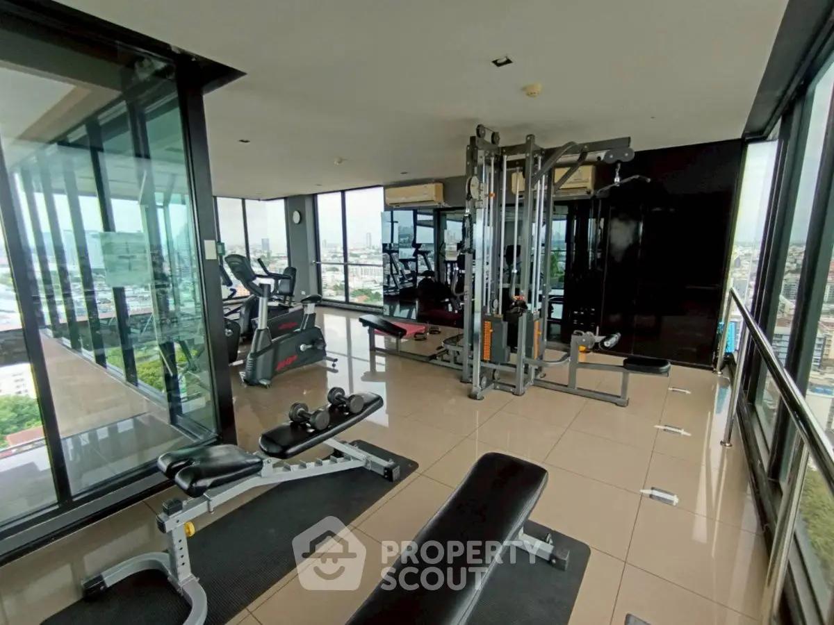 Modern gym with panoramic city views and state-of-the-art equipment in a high-rise building.