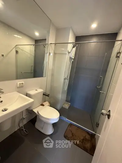 Modern bathroom with glass shower enclosure and sleek fixtures