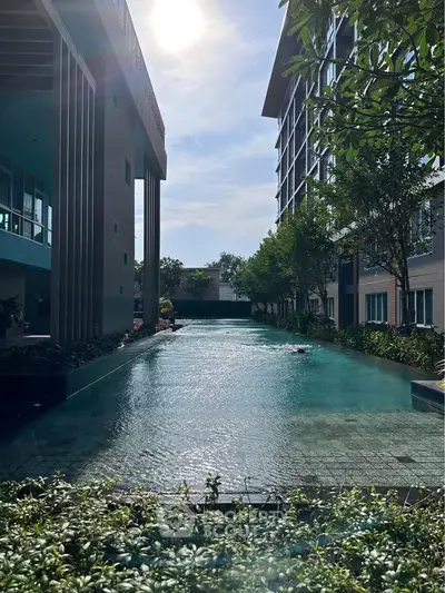 Luxurious residential pool area with modern architecture and lush greenery, perfect for relaxation and leisure.