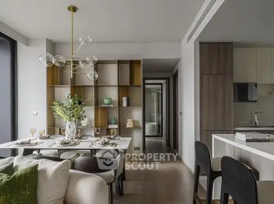 Modern open-plan living and dining area with stylish decor and contemporary lighting.