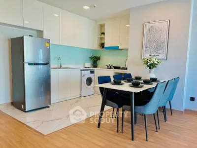 Modern kitchen with dining area, featuring sleek appliances and stylish decor.