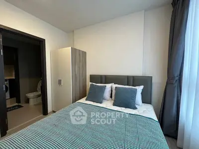 Modern bedroom with stylish decor and ensuite bathroom in a cozy apartment.