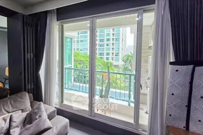 Spacious living room with large windows and balcony view in modern apartment