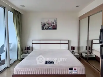 Modern bedroom with large windows and mirrored closet doors