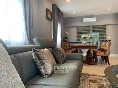 Elegant living room with plush sofa and stylish dining area, perfect for modern living.