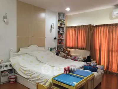 Cozy bedroom with double bed, bookshelves, and warm lighting