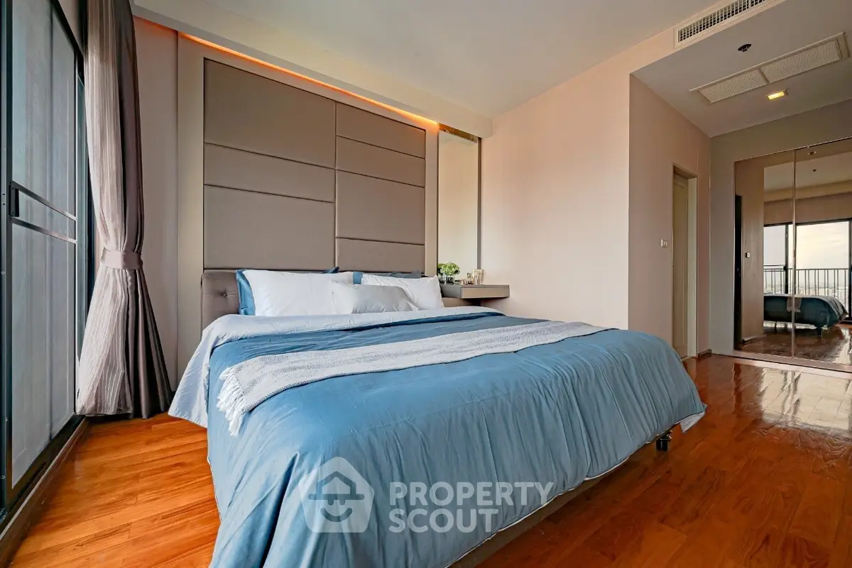 Spacious bedroom with modern decor and large windows offering natural light.