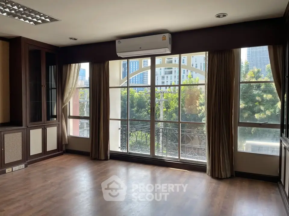 Spacious living room with large windows and city view, perfect for natural light lovers.