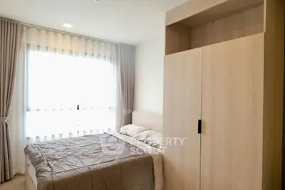 Modern bedroom with large window and stylish wooden wardrobe