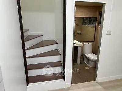 Compact bathroom next to staircase in modern home interior