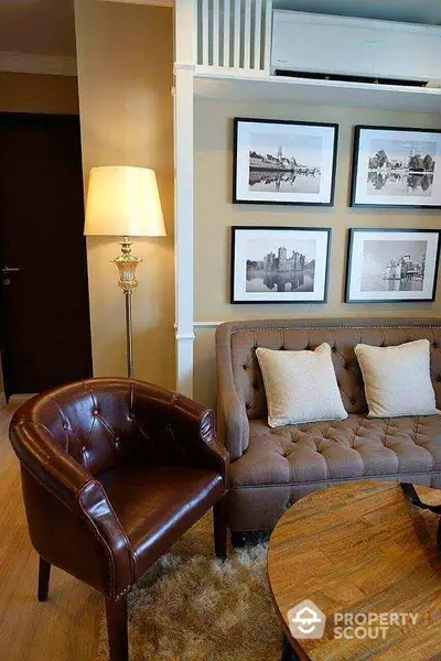 Elegant living room with stylish decor, leather chair, and framed art on the wall.