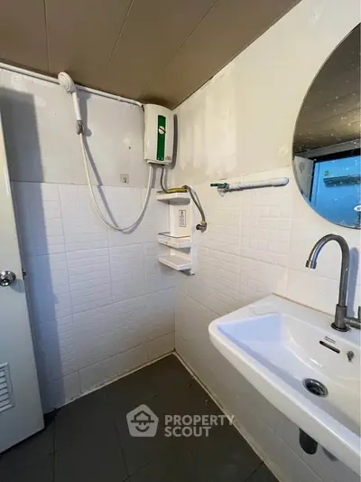 Compact bathroom with modern fixtures and wall-mounted water heater