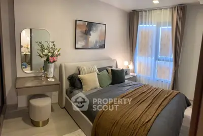 Elegant bedroom with modern decor, plush bedding, and stylish vanity in a cozy apartment setting.