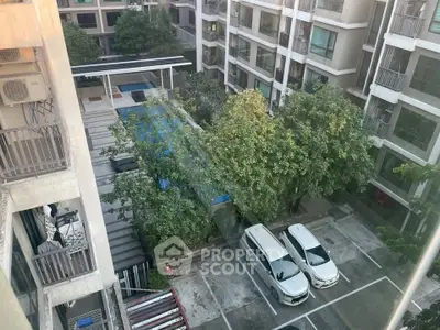 Modern apartment complex with pool and parking view from upper floor.