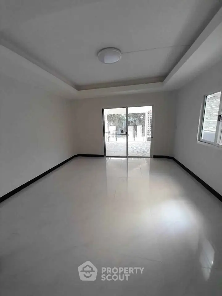 Spacious empty room with large windows and sliding glass door