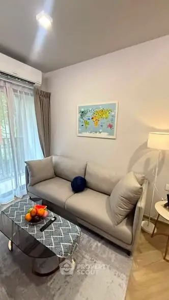 Modern living room with cozy sofa, stylish decor, and natural light from large window.