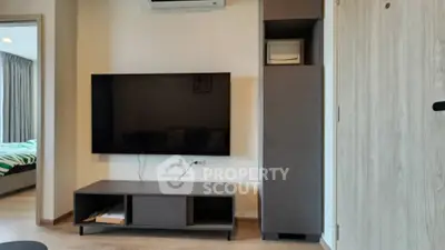 Modern living room with sleek TV setup and air conditioning, showcasing contemporary interior design.