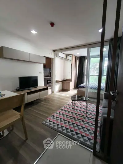 Modern living room with stylish decor and open layout, featuring a cozy seating area and large windows.