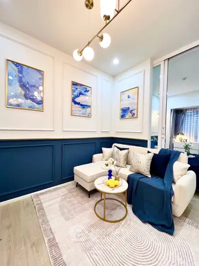 Elegant living room with modern decor, featuring a cozy white sofa, stylish artwork, and chic lighting.