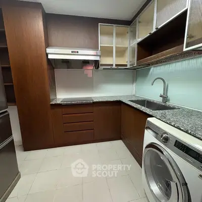 Modern kitchen with granite countertops and washing machine