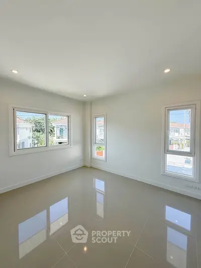 Bright and spacious empty room with large windows and glossy tiled floor, perfect for customization.