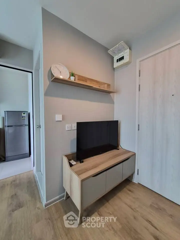 Modern living room with sleek TV stand and wall shelf, showcasing minimalist design and wooden flooring.