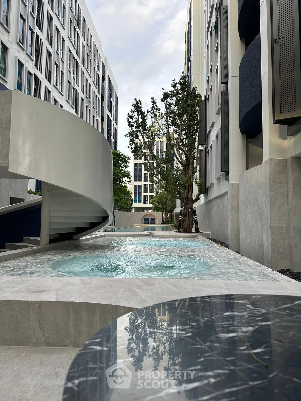 Modern apartment complex with sleek pool and stylish architecture, perfect for urban living.