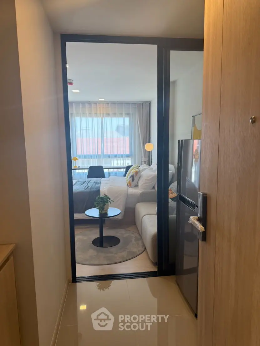 Modern apartment entrance leading to cozy living room with stylish decor and natural light.