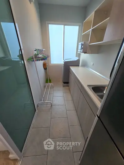 Modern laundry room with sleek cabinetry and natural light