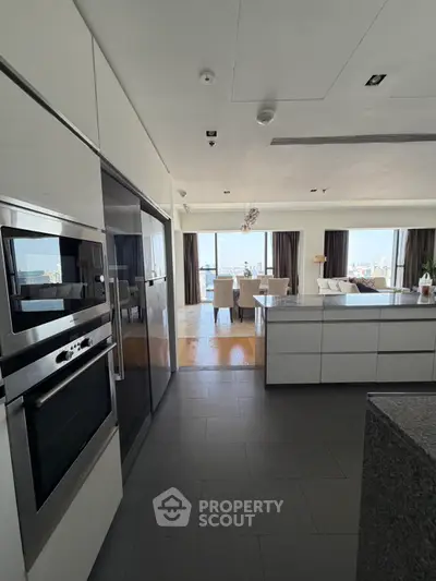 Modern open-plan kitchen and living area with city view