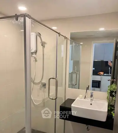 Modern bathroom with glass shower enclosure and sleek sink design