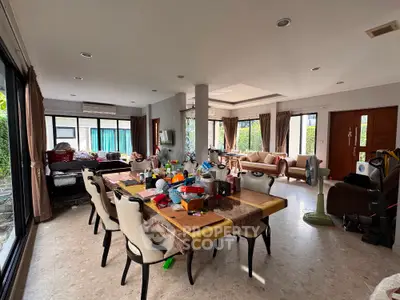 Spacious living room with dining area and large windows in modern home