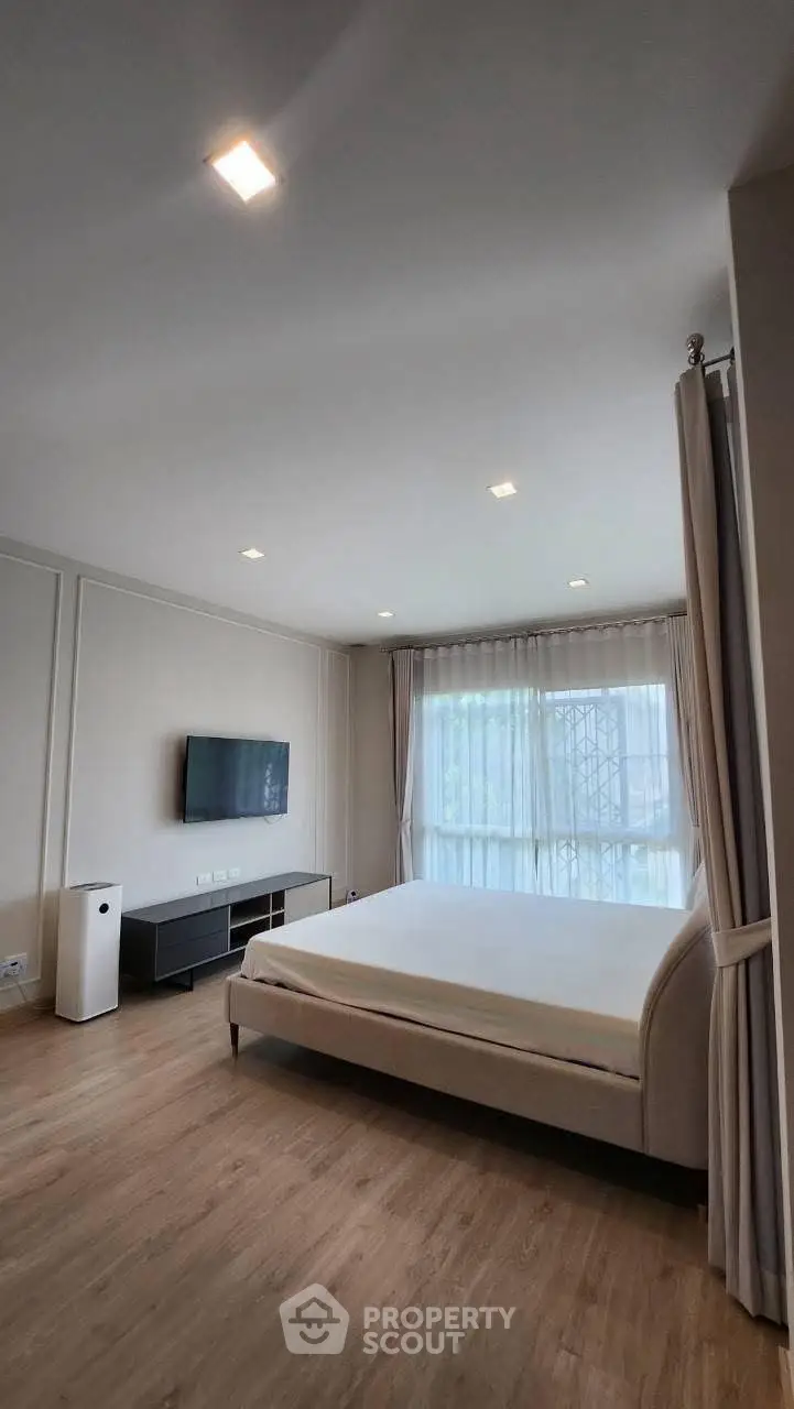 Spacious modern bedroom with large window and minimalist decor